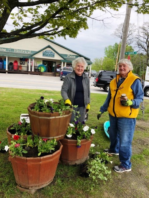 two women with 3 barrels of flowers