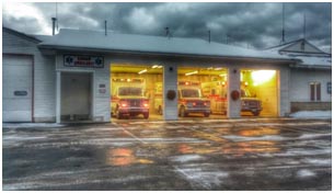 3 ambulances in lit garage bays