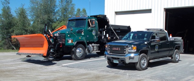 green dump truck and a pick up truck