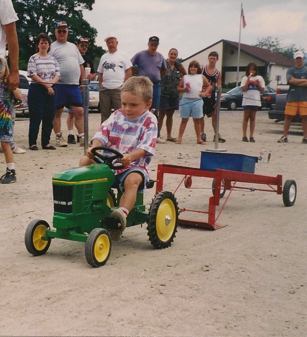 boy competing in toy tractor pull
