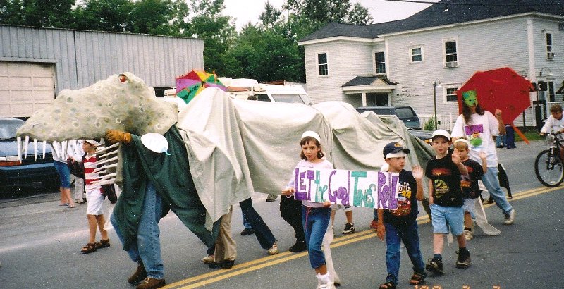 library volunteers and children dressed up as a dinosaur
