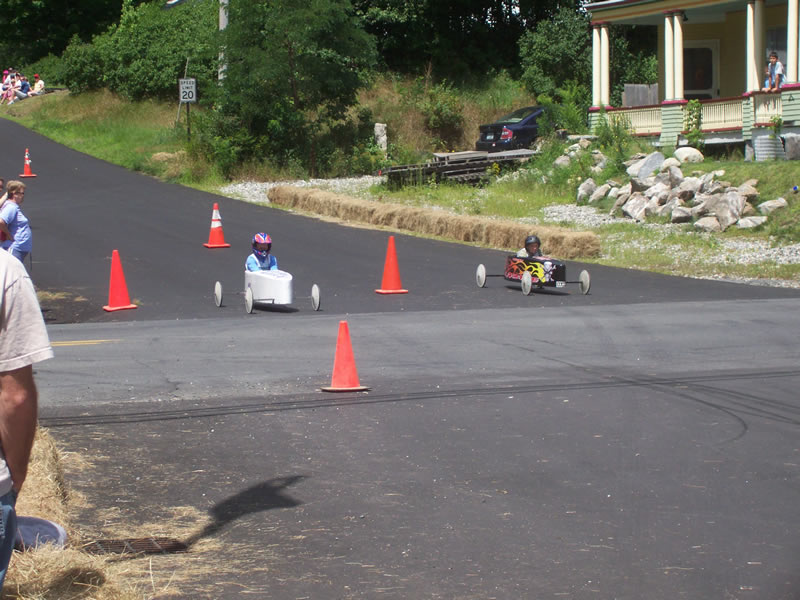 soap box derby cars nearing the finish line