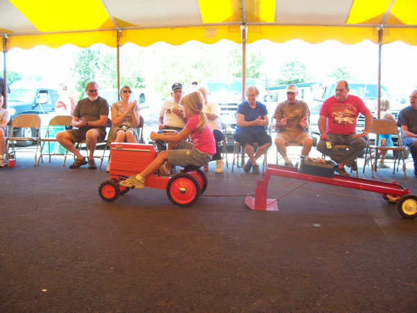 girl competing in toy tractor pull