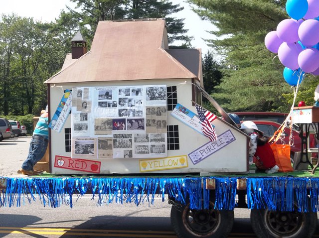 model of old high school being pulled as a float