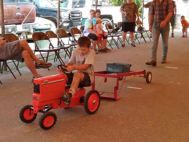 child on toy tractor