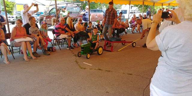 child on toy tractor